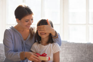 Mom cover daughter eyes with hands prepared surprise for her